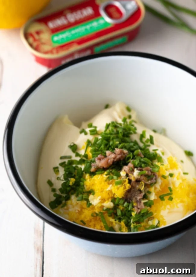 A white bowl with ingredients for aioli sauce.