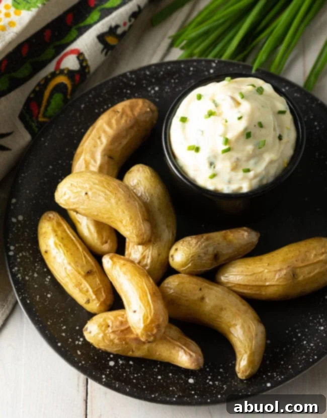 Aioli sauce in a bowl with a plate of fingerling potatoes.