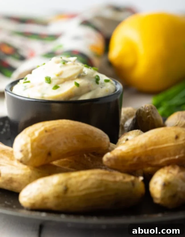 A bowl of aioli sauce on a plate with fingerlings.