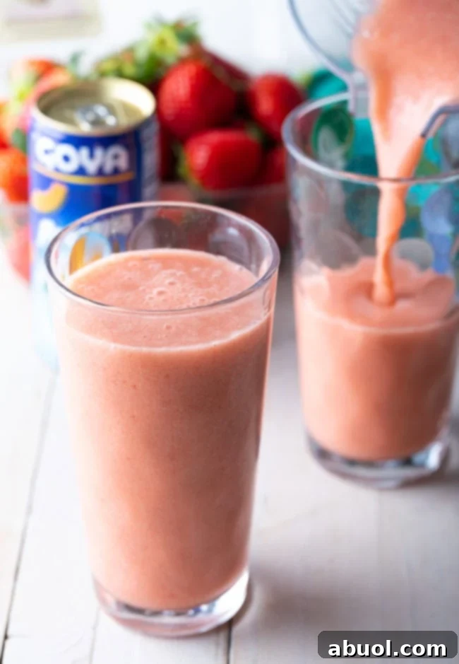 Two glasses of Caribbean Way Smoothie, one being filled from a blender.