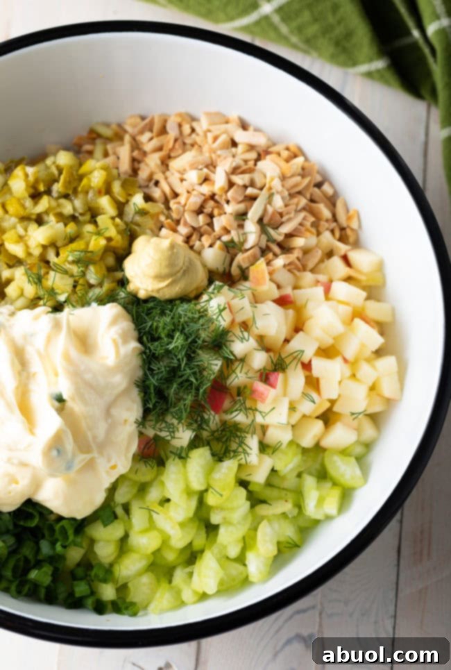 Ingredients for chicken salad, chicken, mayo, celery, apples, pickles, almonds, scallions, dill