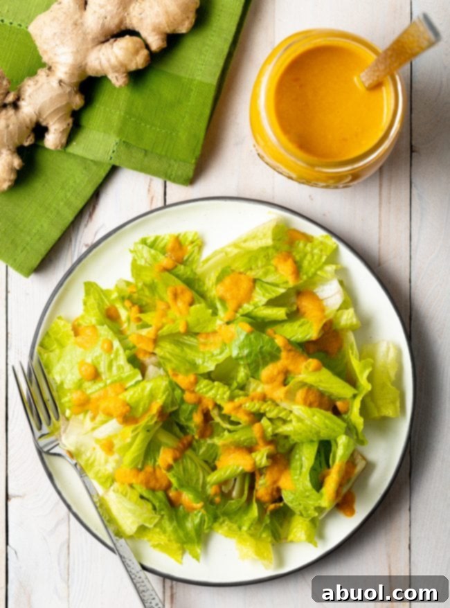 Overhead shot of romaine lettuce drizzled generously with homemade Japanese Ginger Salad Dressing.