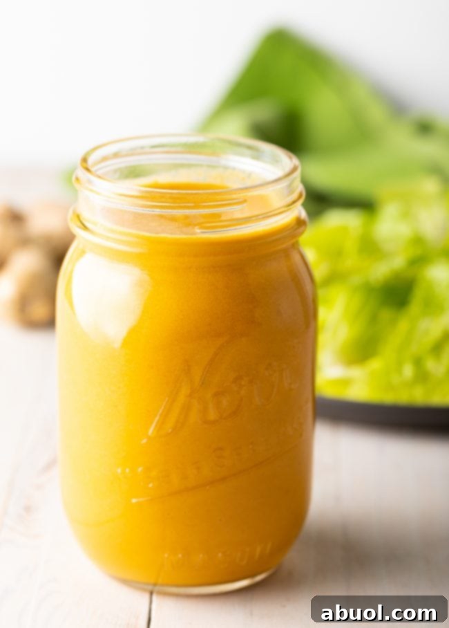 Freshly blended Japanese Ginger Dressing in a clear mason jar, showcasing its vibrant orange color and smooth texture, ready for refrigeration.