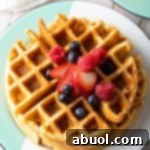 A close-up of a stack of golden crispy waffles, ready to be enjoyed.