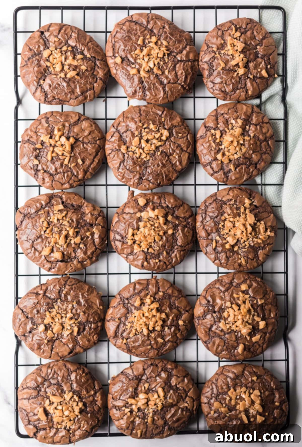 Freshly baked Toffee Brownie Cookies cooling on a rack, generously sprinkled with extra toffee bits for added crunch and visual appeal.
