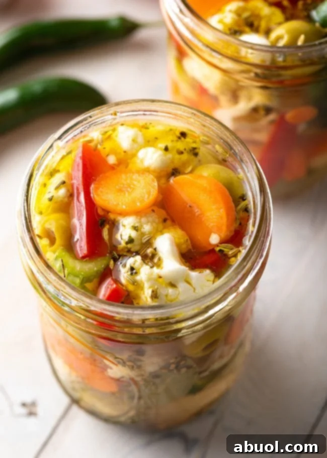 Zesty Italian Giardiniera 12 Pickled vegetables in a jar on a rustic wooden background.