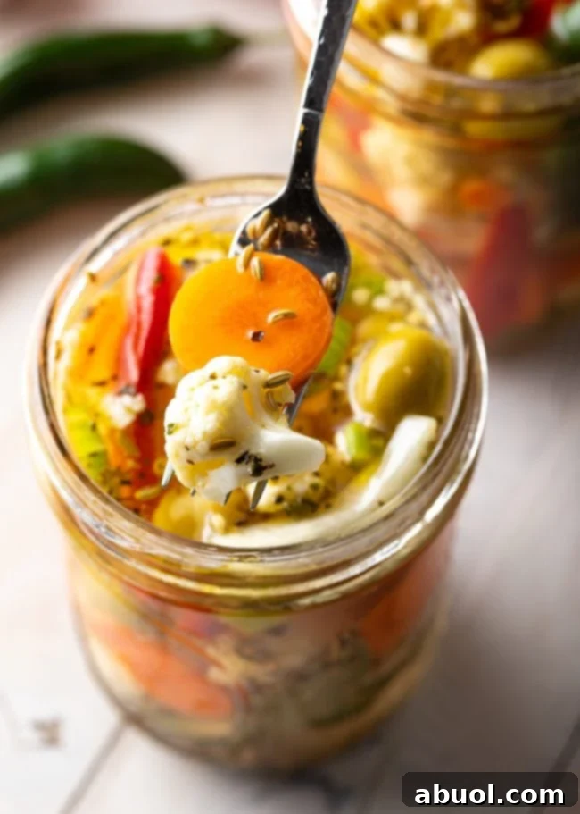 Zesty Italian Giardiniera 5 A fork scooping up some pickled vegetables from a jar.
