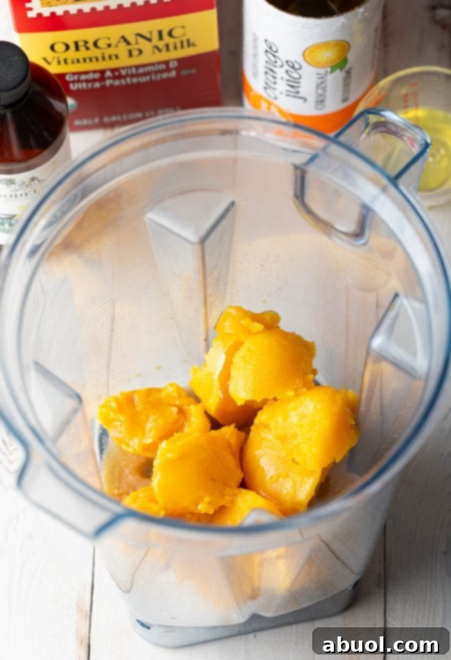 Frozen orange juice concentrate in a blender, ready for other ingredients to be added.
