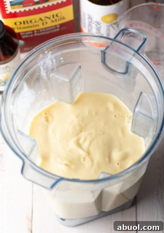 Orange Julius smoothie in the blender after being perfectly blended, showing a frothy texture.