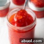 Homemade strawberry freezer jam in a jar with fresh fruit