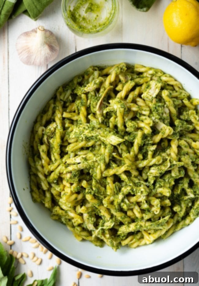 how to make pesto pasta with chicken - shown in large bowl
