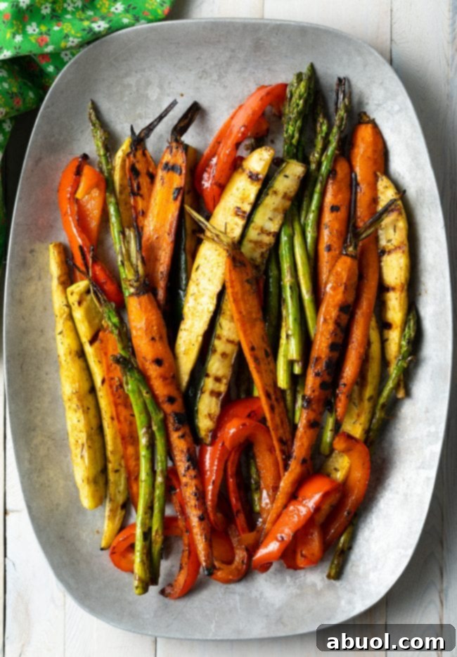 Master Marinade for Grilled Vegetables 2 A vibrant assortment of marinated grilled vegetables, including bell peppers, zucchini, asparagus, and carrots, beautifully arranged on a large serving platter, showcasing their perfect char and appetizing colors.