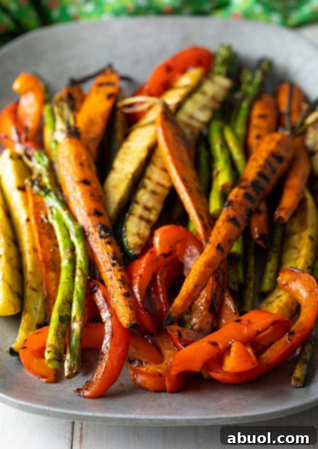 Master Marinade for Grilled Vegetables 4 Close-up of freshly grilled carrots, vibrant green asparagus, golden bell peppers, and tender zucchini, showing off their beautiful grill marks and glistening marinade.
