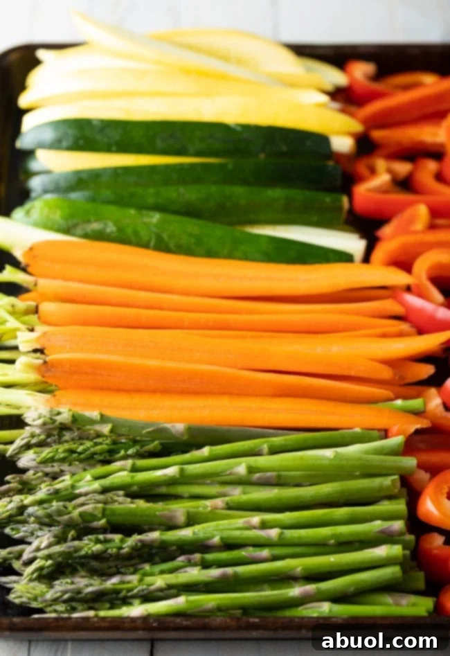 Master Marinade for Grilled Vegetables 6 Close-up of a hand pouring the golden, savory marinade over an array of colorful, sliced vegetables on a baking sheet, ensuring every piece is generously coated.