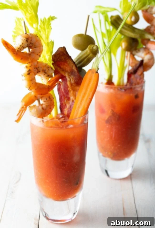 Two glasses of Spicy Bloody Mary Mix Recipe with all the toppings. 