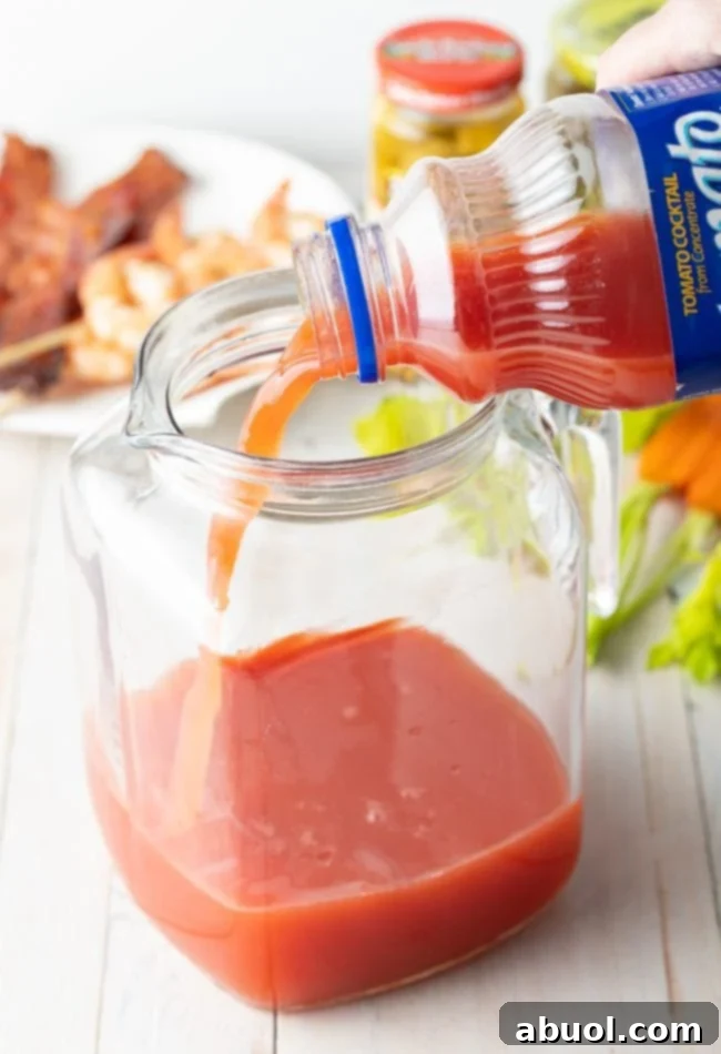 Hand pouring Clamato juice into pitcher. 