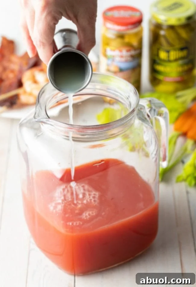 Hand pouring lime and lemon juice into pitcher. 