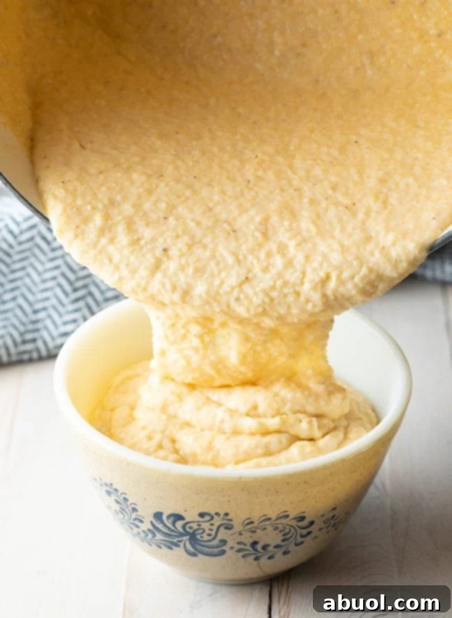 Grits being poured from a pot into a serving bowl. 