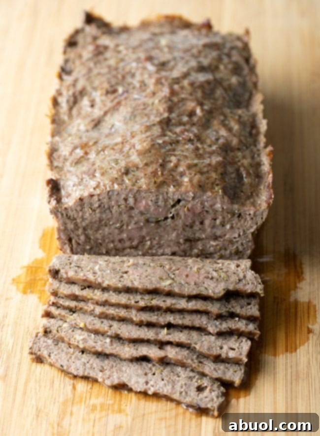 Sliced lamb meatloaf on a cutting board.