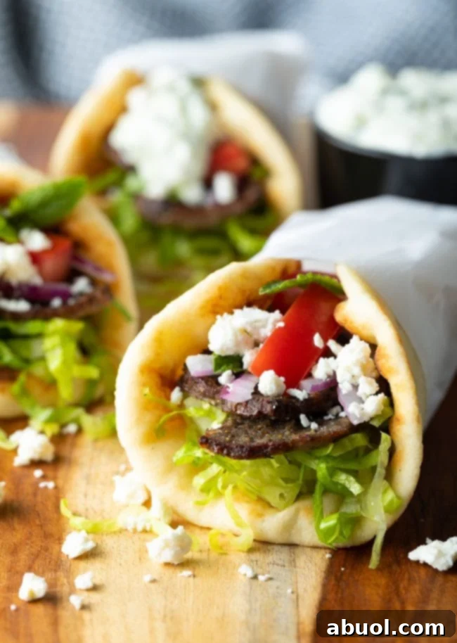 Three authentic greek lamb wraps on a wooden surface.