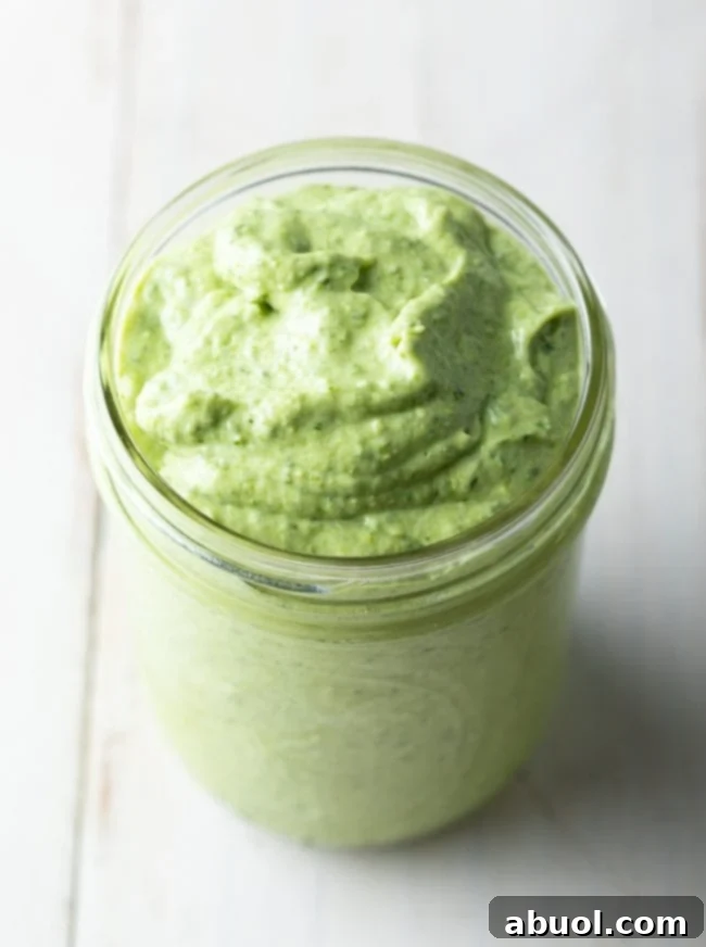 Close up of creamy pesto sauce in a jar. 