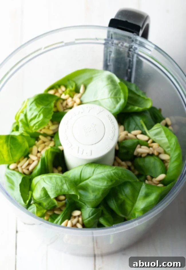 Basil leaves and pine nuts in a food processor. 
