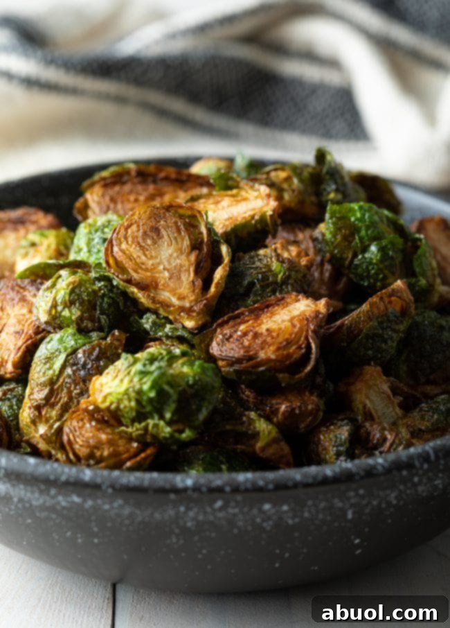 Closeup of a bowl filled with perfectly crispy fried Brussels sprouts.