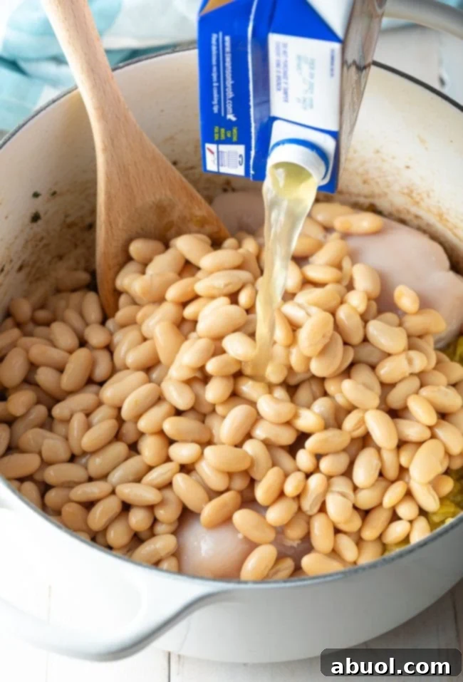 adding broth to the chicken chili