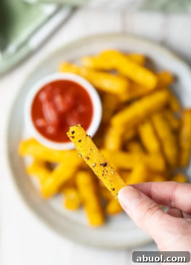 Up close top view of a single oven baked polenta fry and the seasonings on it