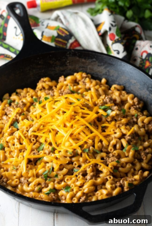 A skillet filled with rich, cheesy homemade cheeseburger macaroni, garnished with fresh herbs.