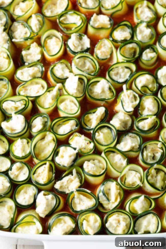 keto zucchini noodles stuffed with cheese in a baking dish, before being baked.