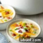 Cozy Stovetop Potato Soup 9 Bowl of loaded baked potato soup in a white bowl.