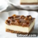 Pecan Pie Cheesecake Recipe (Bars or Cake!) - Gooey caramel Pecan Pie meets tangy classic Cheesecake in this fabulous dessert mashup! Enjoy decadent Pecan Pie Cheesecake as handy bars, or make as a centerpiece-worthy cake for your holiday parties.