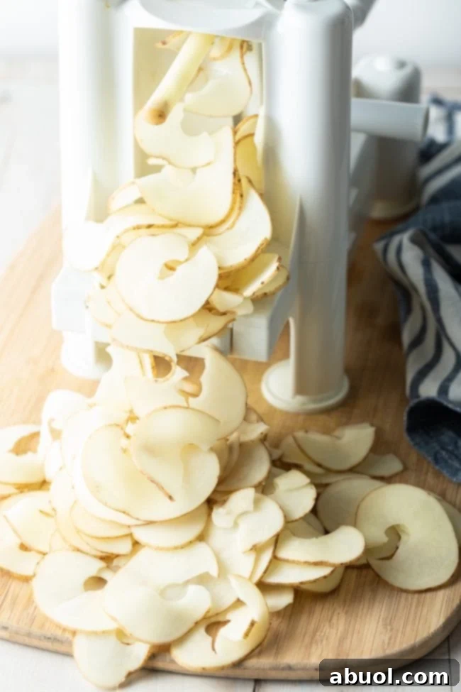 Oven-Baked Crispy Potato Ribbons 4 A spiralizer in action, expertly slicing a potato into delicate, long ribbons.