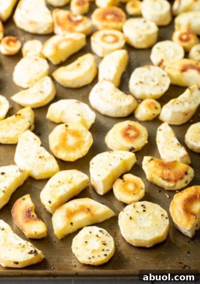Savory Garlic Butter Parsnips 6 Golden-brown baked parsnips evenly spread on a baking sheet, cooked to perfection.