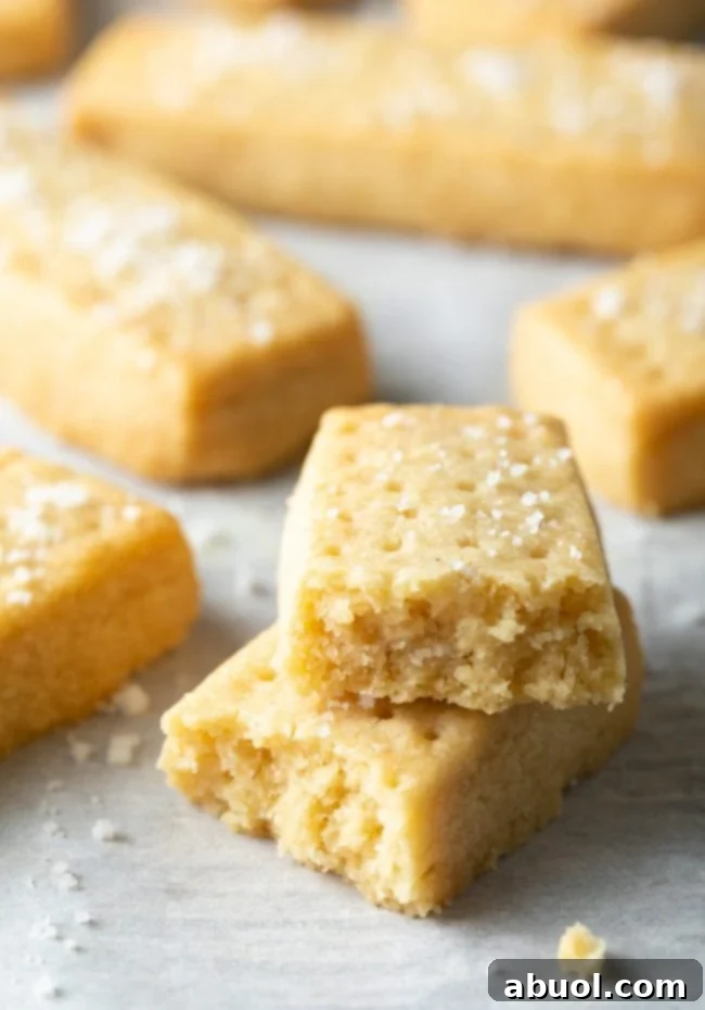 Scottish Shortbread Recipe - Two golden-brown shortbread cookies broken in half and elegantly stacked.