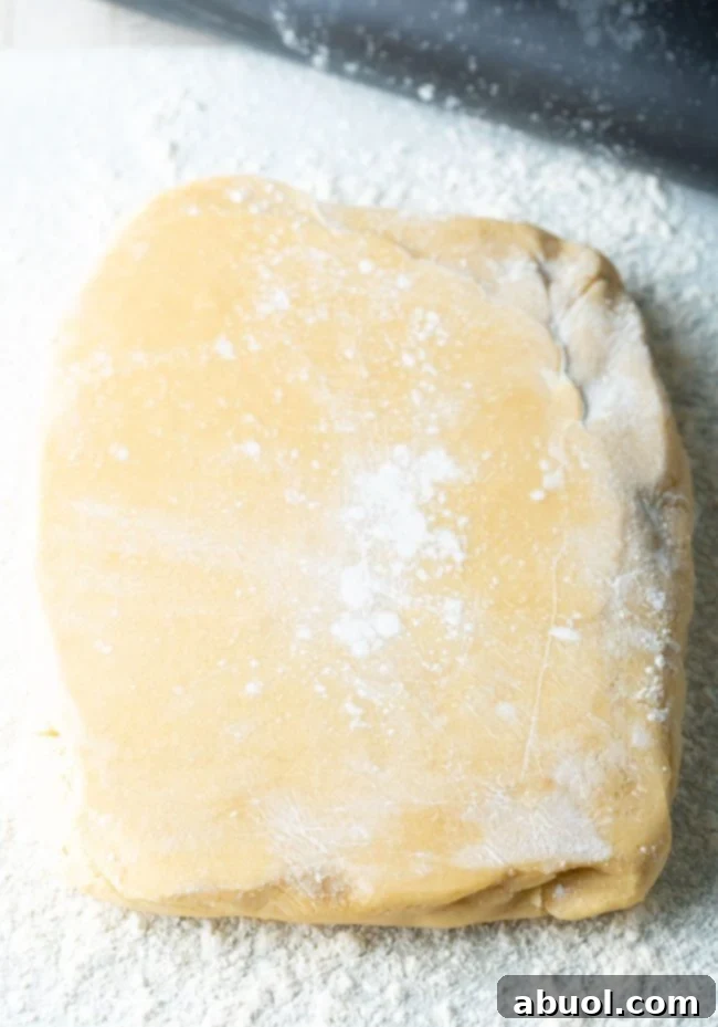 A smooth, rectangular block of chilled shortbread dough on a floured surface.