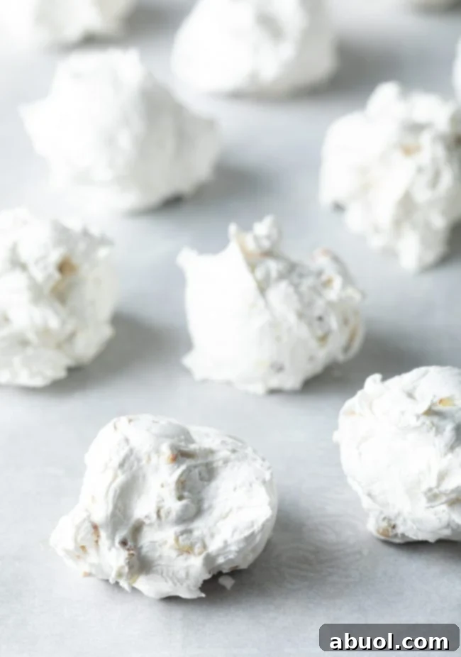 Close up of meringue dolloped onto a baking sheet. 
