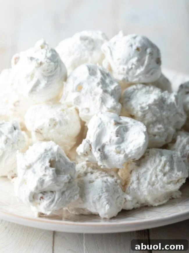 Fluffy pecan and nougat divinity candy piled up on a plate. 