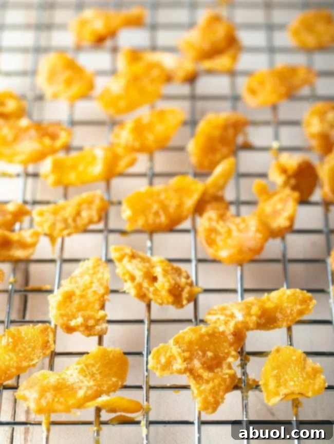Neatly arranged pieces of homemade crystallized ginger candy resting on a cooling rack, drying to perfection.