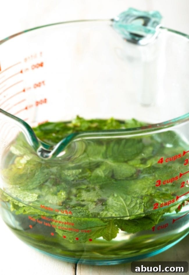Measured mint simple syrup in a measuring cup.
