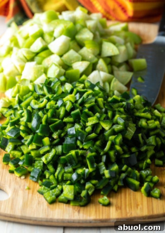 chopped peppers and tomatillos on a cutting board. 