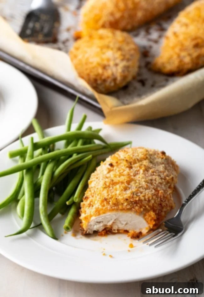Easy oven-baked buffalo chicken breast with green beans, cut to reveal the cooked chicken interior.