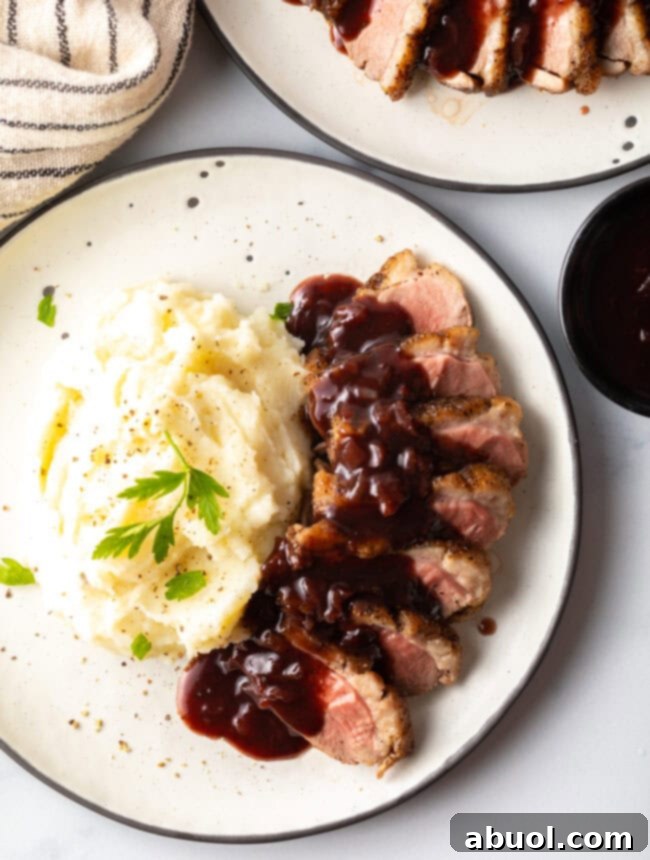 Best duck breast recipe - overhead shot on plate with potatoes and sauce