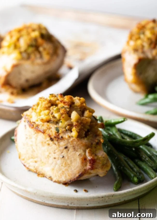 Three plates featuring apple stuffed pork chops with a side of vibrant green beans, ready to be served for a hearty dinner.