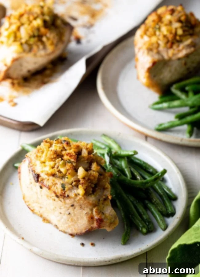 A perfectly plated apple stuffed pork chop alongside a serving of fresh green beans, ready for a comforting meal.