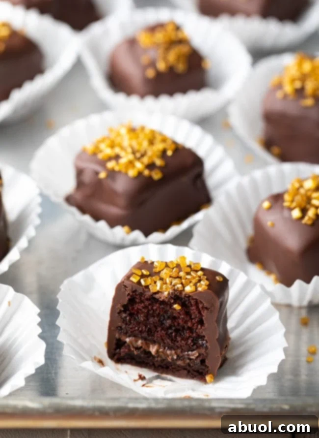 Decadent Chocolate Petit Fours 3 Chocolate petit fours recipe cut in half to show cake and nutella layer inside.
