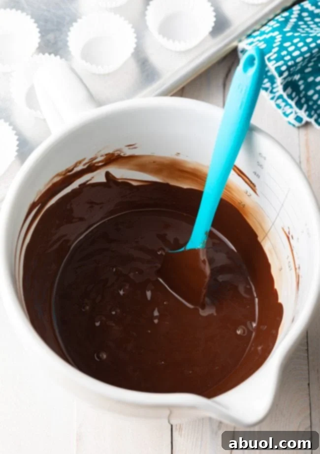 Decadent Chocolate Petit Fours 7 Chocolate ganache in a mixing bowl with a rubber spatula.