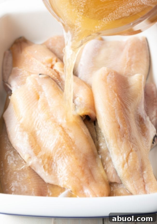 Fillets of trout being covered in brine. 