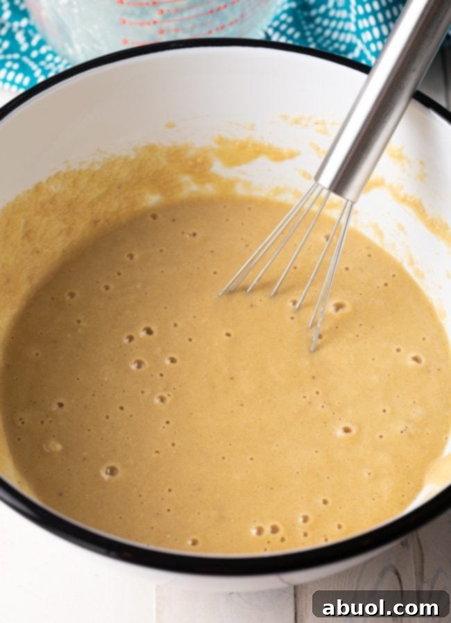 Smooth and creamy almond pancake batter resting in a bowl, ready to be cooked on the griddle for fluffy pancakes